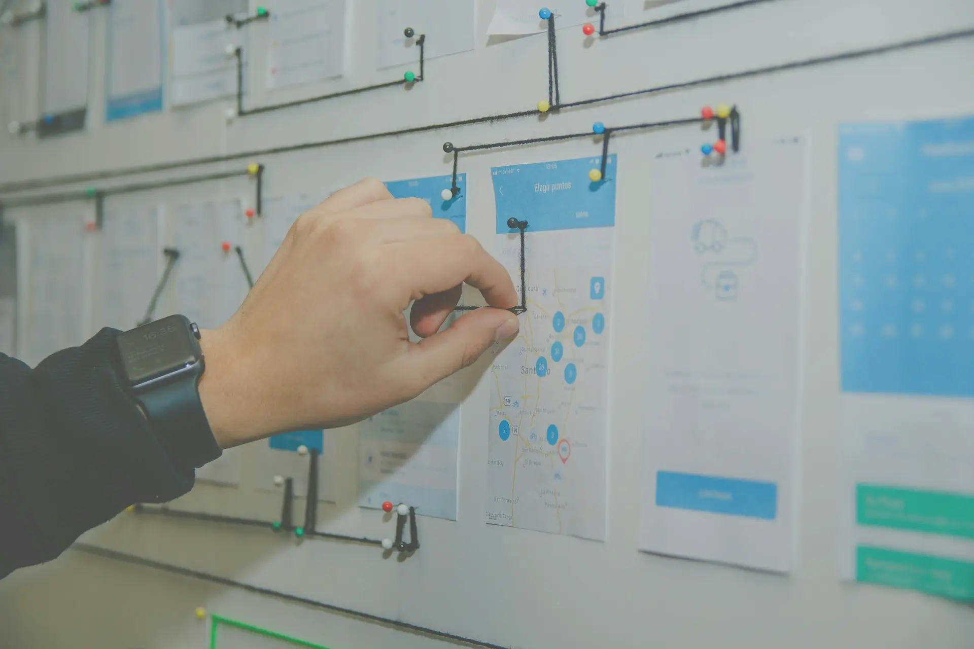 person working on blue and white paper on board